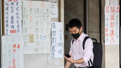新冠肺炎疫情未停，台北市中山区一间诊所外贴满手写字条，提醒大家遵守防疫规定。（图取自中央社）