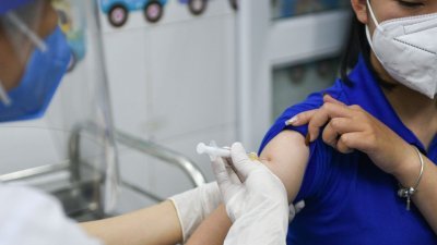 去年3月在越南海阳省一家医院，一名妇女接种新冠肺炎疫苗。（图取自路透社档案照）