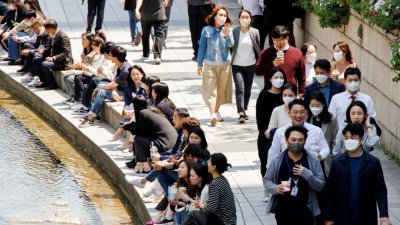 随著更具传染性的Omicron BA.5变异株在韩国扩散，该国新增确诊病例创下两个月来新高。今年5月3日，首尔民众带著口罩在阳光明媚的春日散步。（图取自路透社档案照）