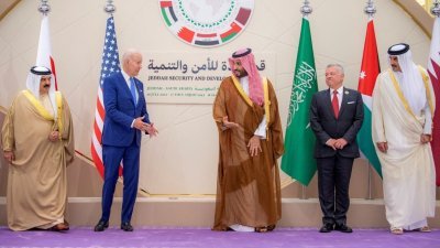 在拍全体照时，沙特王储穆罕默德（中）示意美国总统拜登（右二）先上前站。（图取自Bandar Algaloud/沙地王宫/路透社）