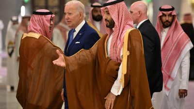 沙地王储穆罕默德和美国总统拜登在拍全体照时互动。（图取自路透社）