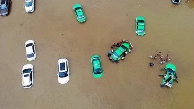 近来因气候变迁导致全球天气异常，中国四川和甘肃爆发山洪导致至少12人死。图为甘肃省兰州市降下暴雨，民众正奋力将泡水车辆推离积水区。（图取自网络）