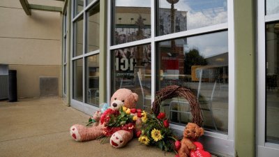 造成3死2伤的购物中心枪击案发生后，有民众献上花圈和玩偶，悼念无辜的死者。（图取自路透社）