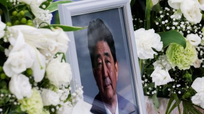 日本已故前首相安倍晋三的遗照，摆放在东京自民党总部的献花台上。（图取自路透社）