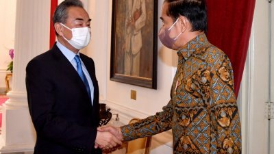 印尼总统佐科（右）本月11日在雅加达总统府，接待到访的中国国务委员兼外长王毅。（图取自印尼总统府/路透社）