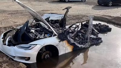 一辆报废的特斯拉Model S，在美国加州萨克拉门托市一处停车场自燃，眼见汽车一再重燃，消防员只能挖了水坑，将车的电箱淹在水中，才将火扑灭。（图取自网络）