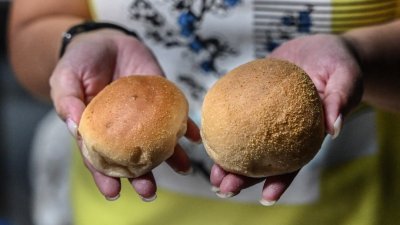 因应通货膨胀高涨，一款热门早餐“菲律宾咸面包”（pandesal）被迫“缩水”。图为面包缩减重量后的大小。（图取自法新社）