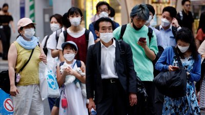 东京街头可见民众都戴上口罩，做好防疫措施。（图取自路透社）