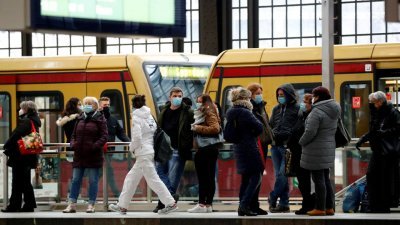 戴著口罩的乘客，在德国首都柏林的腓特烈大街站月台上等待列车。（图取自路透社）