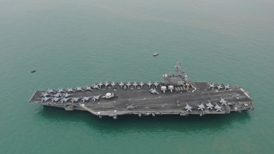 美国“里根”号航空母舰于2018年11月25日访问香港后离开维多利亚港。（图取自财新传媒/路透社档案照）