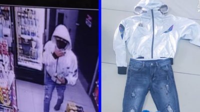 一名劫匪身穿白色外套与牛仔裤，遭闭路电视摄下。