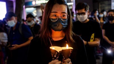香港警方去年以新冠肺炎疫情为由关闭维园，但仍有香港民众在6月4日当天自发在铜锣湾区手持蜡烛纪念“六四”天安门事件。（图取自法新社档案照）