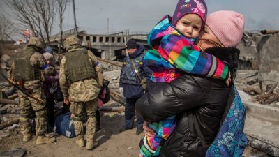 位于基辅州伊尔平镇的家园持续遭到俄军袭击，一名女子抱著孩子站在一座被毁的桥梁旁边，等待撤离。（路透社档案照）