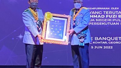 曹观友（左起）颁发纪念品予槟州元首敦阿末弗兹，感谢槟元首前来为童军们颁发勋章及奖状。
