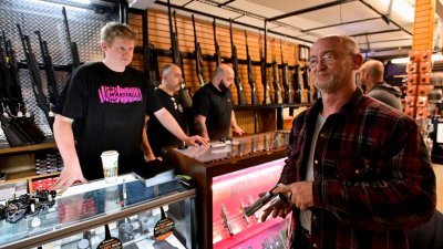 加拿大总理特鲁多提议冻结手枪贩售，一些加拿大人听到消息后赶赴枪支店，想在还能买枪时购买。图为英属哥伦比亚省一间枪店，客人正在购买手枪。（图取自路透社）