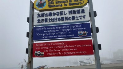 在日本北海道根室的Hanasaki港，展示了用日文、俄文和英文要求俄罗斯归还北方四岛的标志。（图取自路透社档案照）