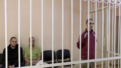 “顿涅茨克人民共和国”法院判处协助乌克兰抗战的2英国公民和1摩洛哥公民死刑，图为3人上庭受审画面。（图取自“顿涅茨克人民共和国”最高法院/路透社）