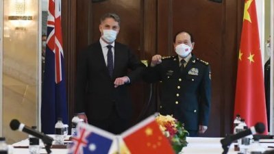 澳洲国防部长马尔斯（左）与中国防长魏凤和于周日在新加坡香格里拉安全峰会上会面。（图取自澳洲副总理办公室/英国《卫报》）
