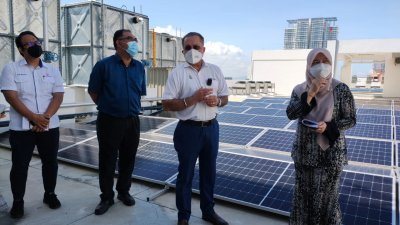 佳日星（左3）周一巡视槟岛市政厅执法机构建筑上安装的太阳能板。