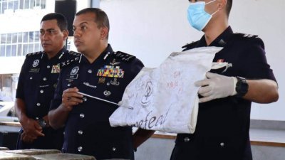阿育甘（左2）展示槟州警方与武吉安曼肃毒合力起获的大麻毒品，市价总值212万令吉。