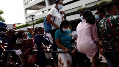 图为6月8日，大批民众前往斯里兰卡首都科伦坡的移民局，排队等待领取护照或提交护照申请。（图取自路透社）