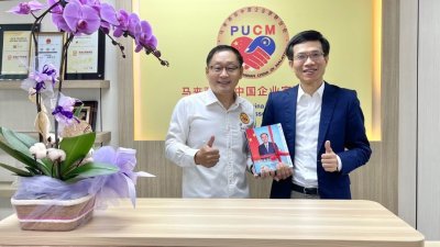 李中平（左）赠送马中企业家联合会官方杂志《马中企业家》予谢少雄。