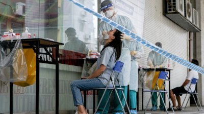 一名澳门妇女日前在检测站接受鼻拭子新冠病毒检测。（图取自路透社）