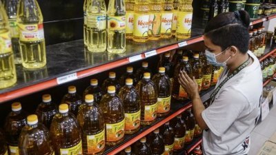 政府宣布7月起取消5公斤罐装食油津贴布，新山地区多家大型商场出现消费者争相购买5公斤罐装食油现像。（档案照）