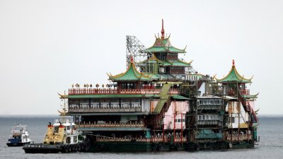 伴随港人40年的著名地标珍宝海鲜舫于14日被拖离香港。（图取自路透社）