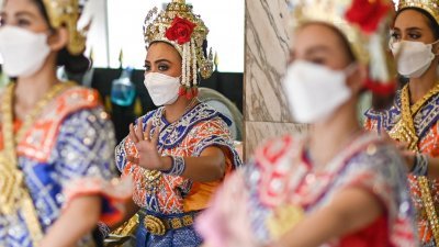 周五，在泰国曼谷叻巴颂十字路口四面佛神坛，舞者戴著口罩翩翩起舞。（图取自法新社）
