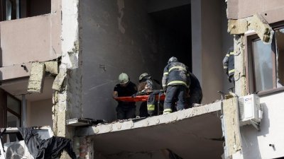救援人员正努力将被困瓦砾堆下的受害者抬出受损大楼。（图取自路透社）