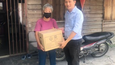 梁智伟（右）代表霹州政府移交粮食盒给有需要的家庭。
