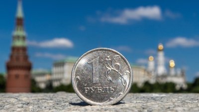 在这张2022年6月24日拍摄的插图照片中，莫斯科克里姆林宫前的一枚卢布硬币。（图取自路透社）