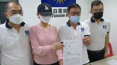 受害者妹妹林小姐（左2）在吴荣炎（左起）、蔡振川及薛志豪陪同下，展示报案纸。
