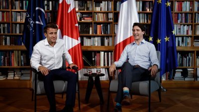 在德国出席G7峰会的法国总统马克龙（左）与加拿大总理特鲁多，当地时间周一举行双边会谈。（图取自法新社）
