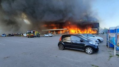 购物中心遇袭后起火燃烧，消防员忙著扑灭大火。（图取自乌克兰国家紧急服务部门/法新社）
