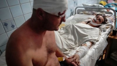 因购物中心遇袭而被送入医院的伤者中，一名丈夫握著躺在病床上伤势较严重的妻子的手。（图取自路透社）