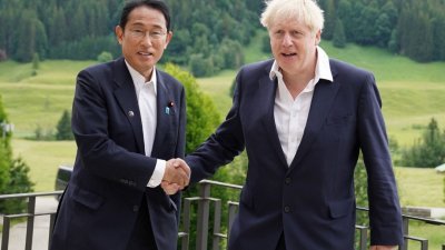 英国首相约翰逊（右）与日本首相岸田文雄当地时间周二，在G7峰会场边举行双边会晤。（图取自路透社）