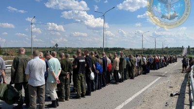 在乌克兰的扎波罗热，交换的战俘周三在马路旁排队。（图取自乌克兰军事情报局/路透社）