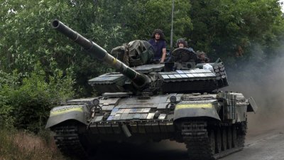 载著乌克兰士兵的坦克于上周四，走在东部卢甘斯克地区的一条道路上。（图取自法新社）