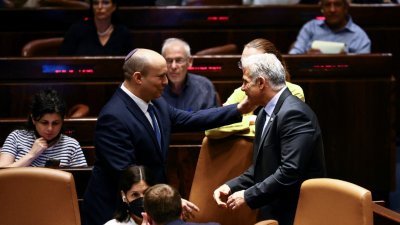 周四，在以色列议会解散后，以色列外长拉皮德（右）和即将卸任的总理贝内特交换席位。（图取自路透社）