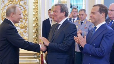 2018年5月7日拍摄的照片显示，当时普京（左）在克里姆林宫举行的总统就职典礼上与德国前总理施罗德握手。（图取自俄罗斯卫星通讯社/法新社）