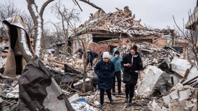 在乌克兰西北部城市日托米尔，数名女子走在被俄军炮击毁坏的住宅残骸中。（图取自路透社）