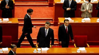 中国全国政协13届5次会议周五下午在北京人民大会堂开幕，中国国家主席习近平（中）和总理李克强（右）等核心领导人陆续进场就坐。（图取自路透社）