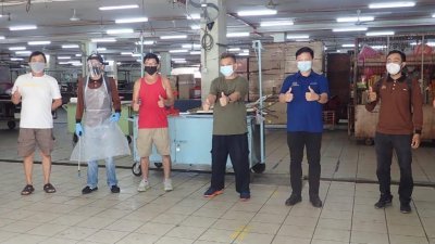 李伟铤（左6）安排市议会消毒团队为太平贩商大厦消毒，并获得小贩们给予赞扬。