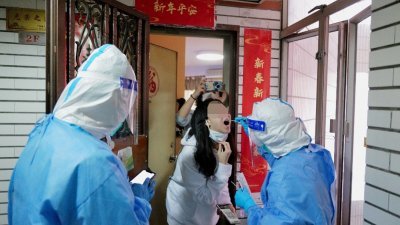 中国广东省深圳市周一起封城，防疫人员全副武装上门为禁足在家的民众，进行筛检。（图取自路透社）
