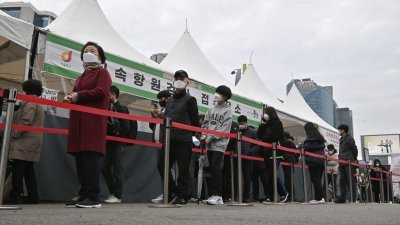 韩国民众周四在首尔市的一个病毒检测中心排队，等待接受新冠病毒检测。（图取自法新社）
