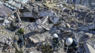 乌克兰南部尼古拉耶夫一座军营周五清晨遭俄军空袭炸毁，搜救团队和军人周六在瓦砾堆下寻找尸体和幸存者。（图取自法新社）