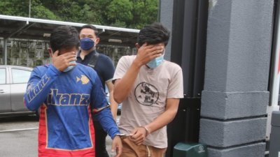 莫哈末菲道兹(左起）与阿曼法希今早被提控，两人以手遮住脸以躲避媒体拍摄。
