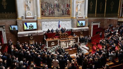 乌克兰泽连斯基当地时间周三透过视讯向法国国会演说，出席的议员们起立鼓掌。（图取自法新社）